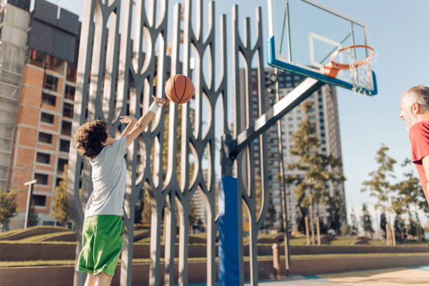 istock Boy taking a shot while playing basketball with his dad 1298857121