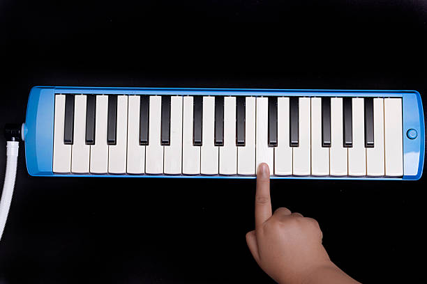istock Hand playing pianica blow-organ musical instrument 1298857162