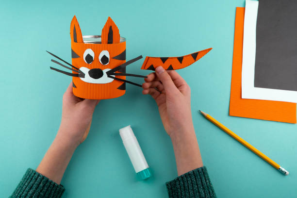 istock Step 6. Step-by-step instructions on how to make a stand for stationery from a tin can. Tiger made of paper and cardboard, scissors and glue. A fun DIY craft for children. Do it yourself paper tiger 1298858784