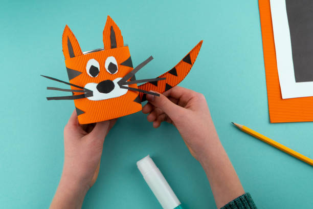 istock Step 7. Step-by-step instructions on how to make a stand for stationery from a tin can. Tiger made of paper and cardboard, scissors and glue. A fun DIY craft for children. Do it yourself paper tiger 1298858960