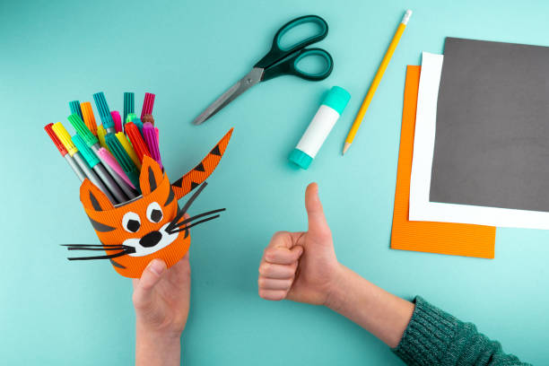 istock Step 8. Step-by-step instructions on how to make a stand for stationery from a tin can. Tiger made of paper and cardboard, scissors and glue. A fun DIY craft for children. Do it yourself paper tiger 1298859168