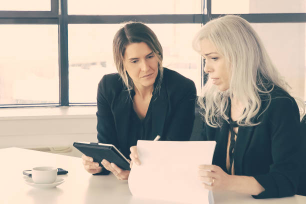 istock Serious businesswomen discussing reports 1298861434
