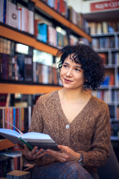 istock Girl enjoying in library and reading book. 1298861950