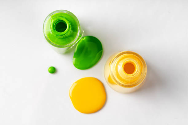 istock Bright colored nail polish bottles with drippings on white background 1298863774