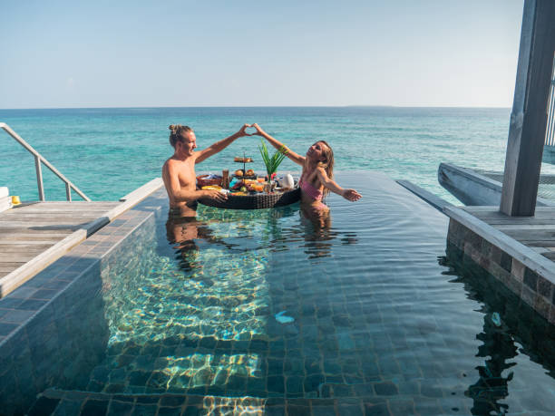 istock Couple enjoying floating breakfast in luxury hotel, heart shape with hands 1298864279