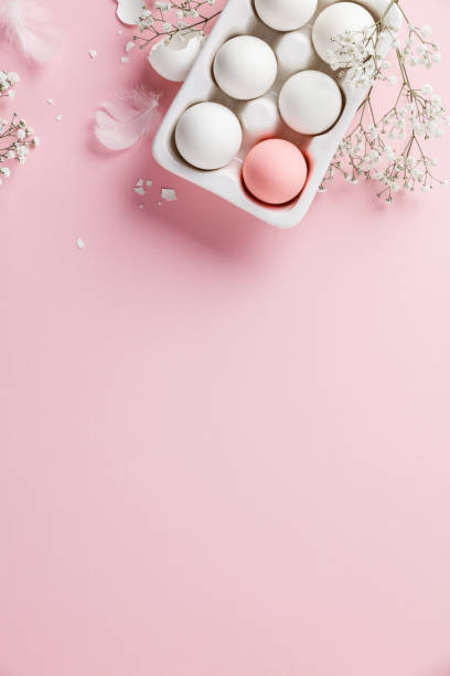 istock Easter eggs in white ceramic holder and flowers on pink background 1298865632