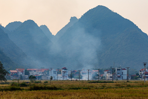 Bac Son, Lang Son, Vietnam - November 21, 2019: Rice fields with farmer in the Bac Son Valley of Vietnam at Sunset