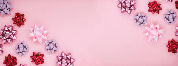 ピンクの背景に異なるピンクの弓の装飾を持つお祝いの組成物。 - differrent ストックフォトと画像