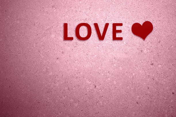 istock Red heart with LOVE text on the pink wall background 1298867931