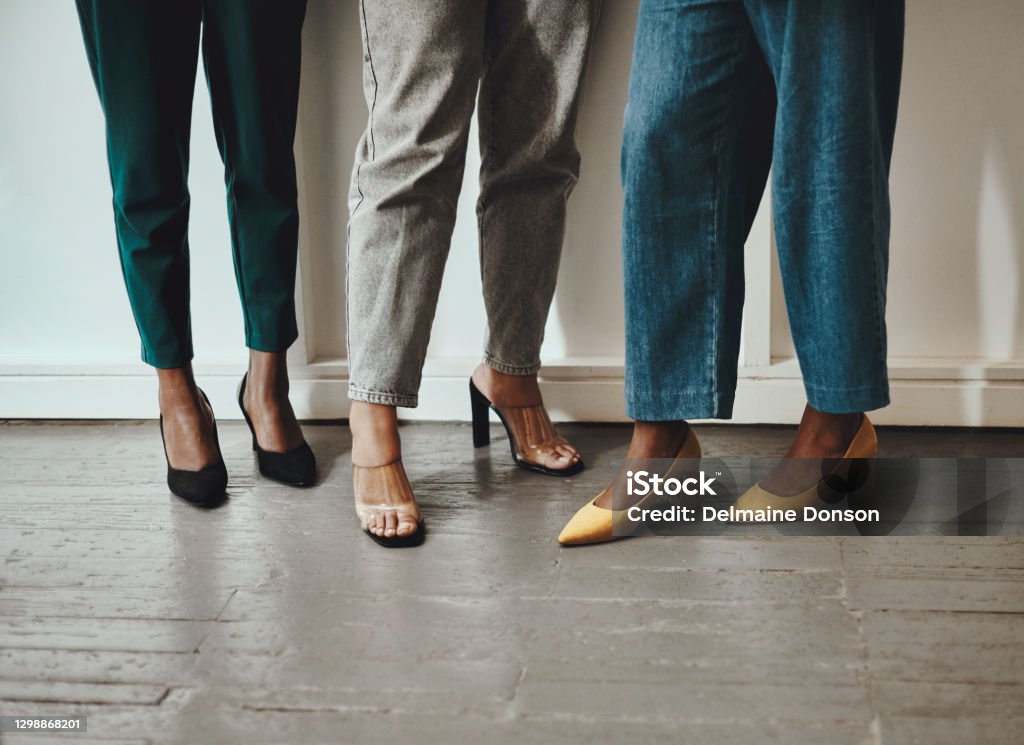 Success that's higher than our heels Shot of a group of unrecognisable businesswomen standing together in a modern office Shoe Stock Photo