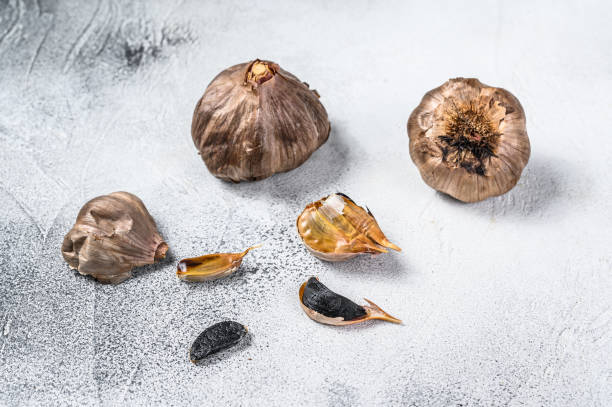istock Whole balsamic fermented  black garlic. White background. Top view 1298870306