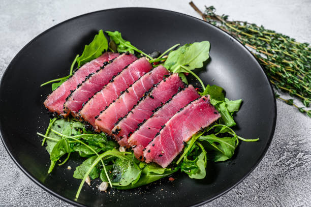 insalata di bistecca di tonno con rucola e spinaci. sfondo bianco. vista dall'alto - tuna steak fillet food plate foto e immagini stock