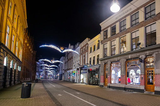 Empty Diezestraat shopping street in the city center of Zwolle at night with illuminated shop windows.