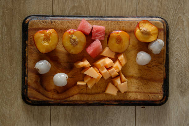 istock Selection of Fresh Fruit cut up on a wooden board 1298873081