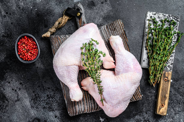 istock Fresh raw chicken legs on a cutting board. Black background. Top view 1298873409