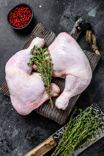 istock Fresh raw chicken legs on a cutting board. Black background. Top view 1298873429