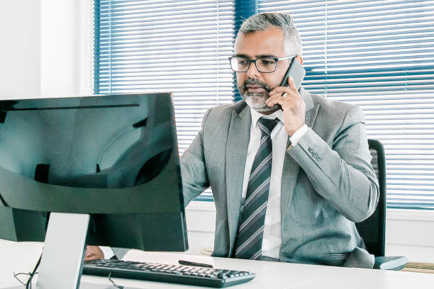 istock Serious mature business leader speaking on cell phone 1298873676