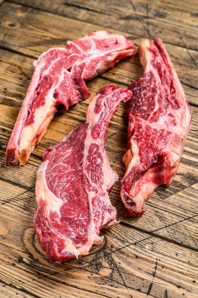 istock Various cuts of raw beef meat. Wooden background. Top view 1298875140