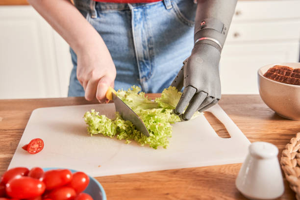 istock Woman with artificial limb chopping salad with a knife 1298875455