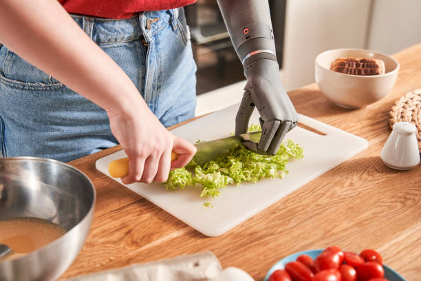 istock Woman with artificial limb chopping salad with a knife 1298875474