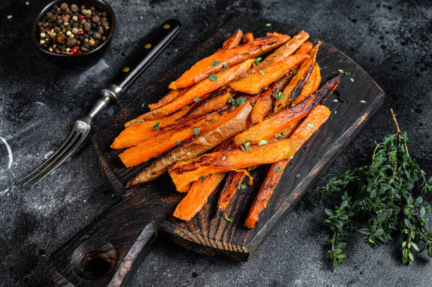 istock Roasted Sweet potatoes stripes. Black background. Top view 1298879799