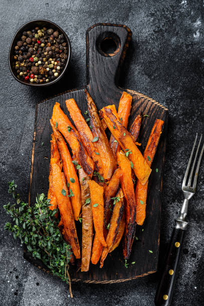 istock Roasted Sweet potatoes stripes. Black background. Top view 1298879857