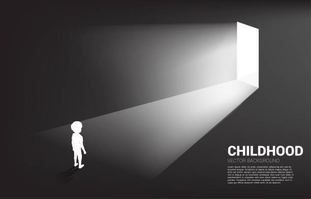 istock Silhouette of boy standing in front of the way out with light. 1298880084
