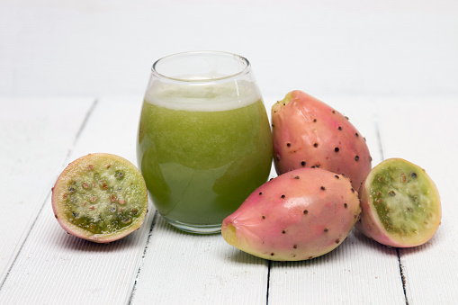 View of drinkable juice made from opuntia ficus-indica cactus fruits on a white background