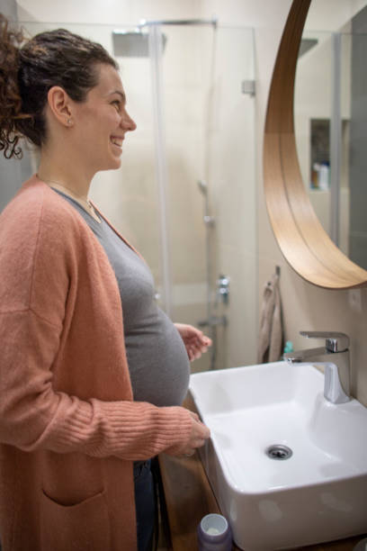 istock Pregnant woman looking in the mirror 1298884654