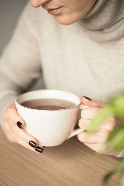 istock Woman holding a cup of tea. 1298885530