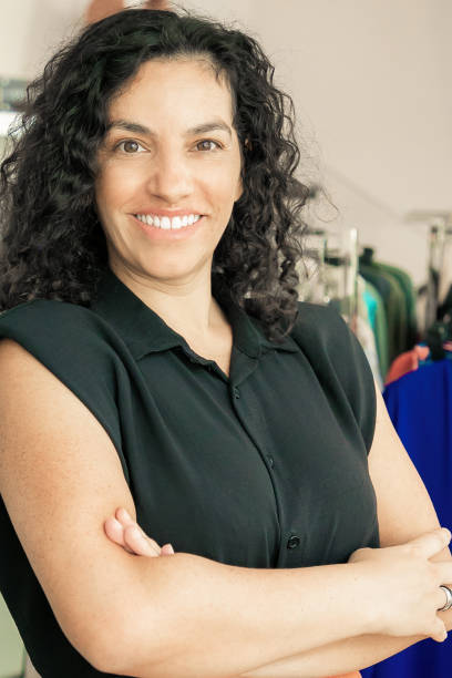 istock Cheerful Latin black haired woman standing with arms folded 1298888241