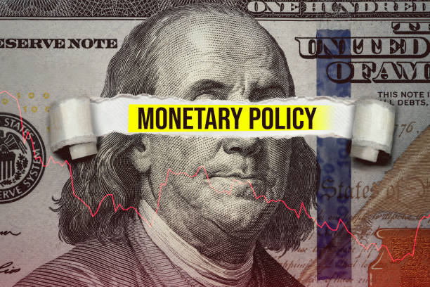 Torn bills revealing Monetary Policy words stock photo