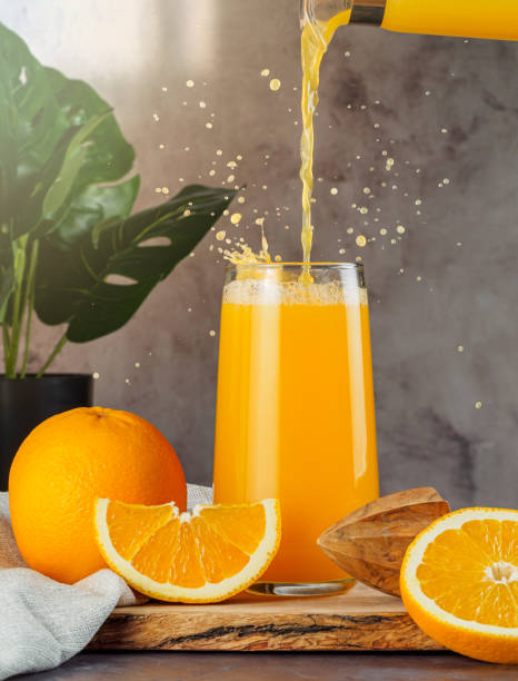 istock Fresh orange juice in a glass with splashes 1298888532