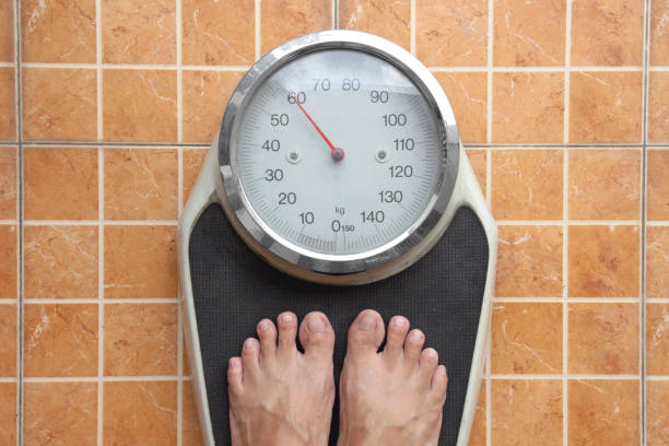 Top view of Weight scale, Man foot step on the weight scale stock photo