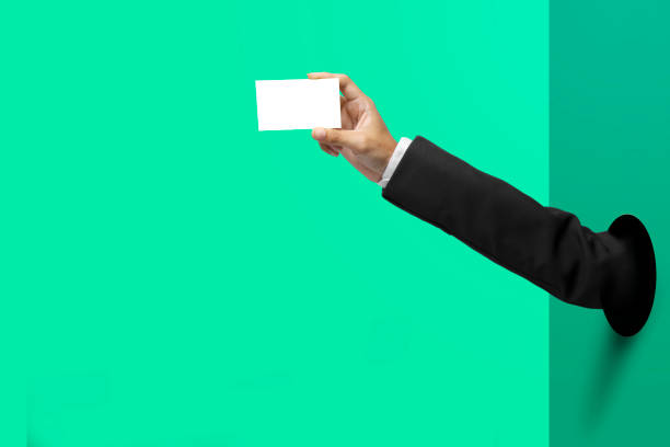 Businessman hand through hole giving business card stock photo