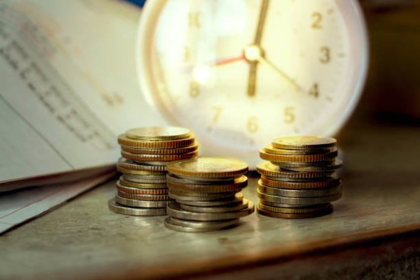 Long term investment, Clock with coins. Idea for Retirement fund stock photo