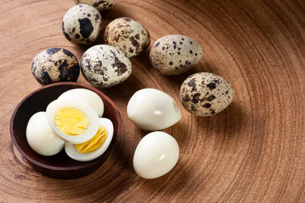 Boiled quail eggs arranged on wooden background