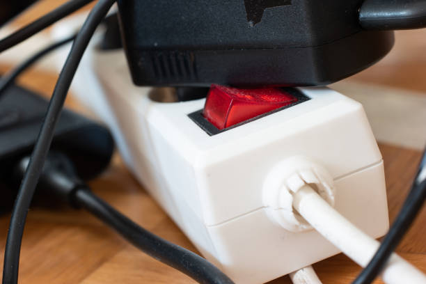 istock Messy outlet power extension cord on an apartment floor with various charging devices plugged in 1298892871