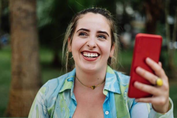 istock Smiling young woman with smartphone 1298894493