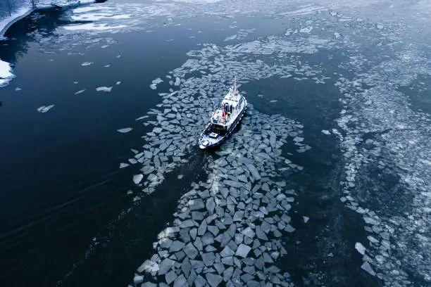 Photo of Aerial view of tug boat pushing through the ice