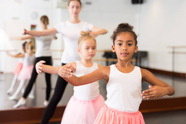 istock Dance teacher helping her little girls students 1298897382