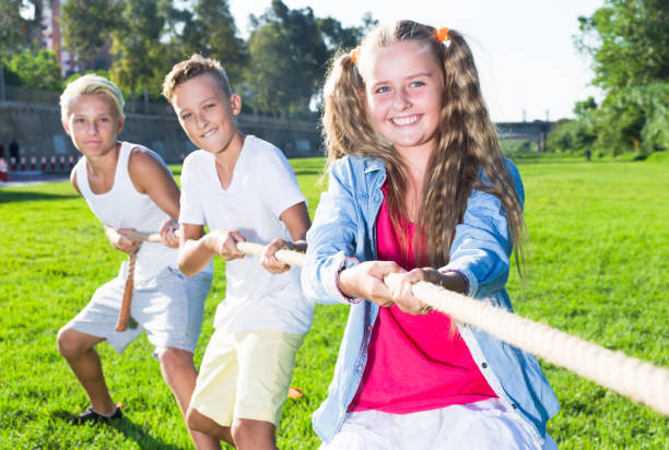 istock Happy kids tugging war in summer park 1298898505