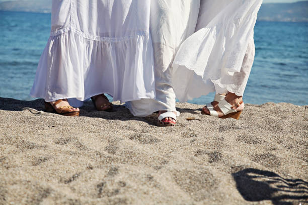 istock Three girls at a beach with white dresses 1298898851