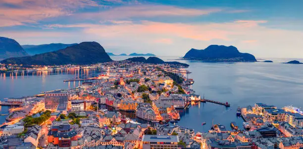 From the bird's eye view of Alesund port town on the west coast of Norway, at the entrance to the Geirangerfjord. Colorful sunset in the Nord. Traveling concept background.