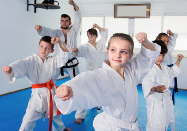 istock Children training karate moves at karate class 1298901123