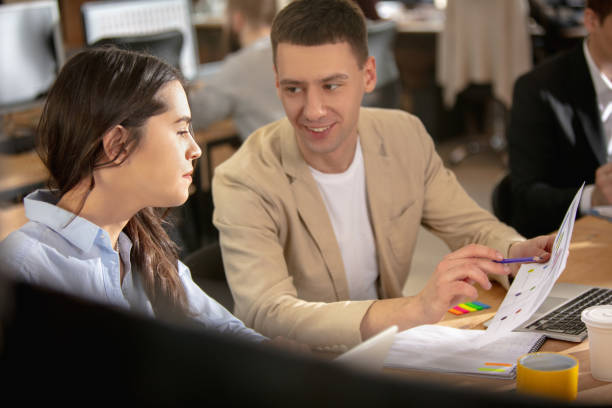 istock Young caucasian colleagues working together in a office using modern devices and gadgets 1298901693