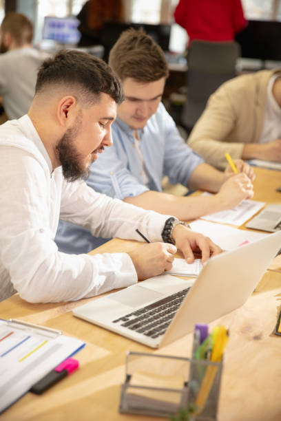 istock Young caucasian colleagues working together in a office using modern devices and gadgets 1298901730