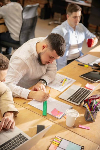 istock Young caucasian colleagues working together in a office using modern devices and gadgets 1298901751
