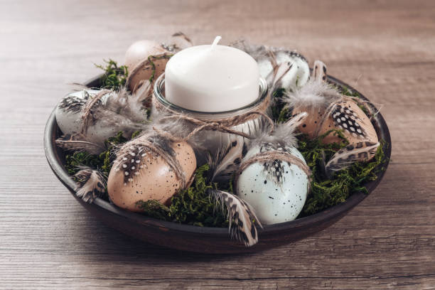 istock Spring decor ideas Diy. How to make Easter floral arrangement with decorative eggs, candle and moss. 1298903251