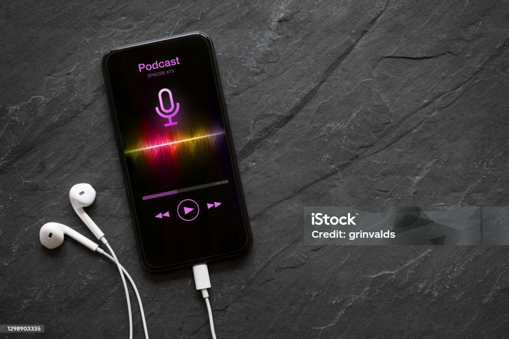 Earphones and mobile phone with podcast app on screen Earphones and mobile phone with podcast app on screen on black background Podcasting Stock Photo